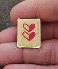 Gold-tone enamel pin with two red hearts and '1 GALLON' text