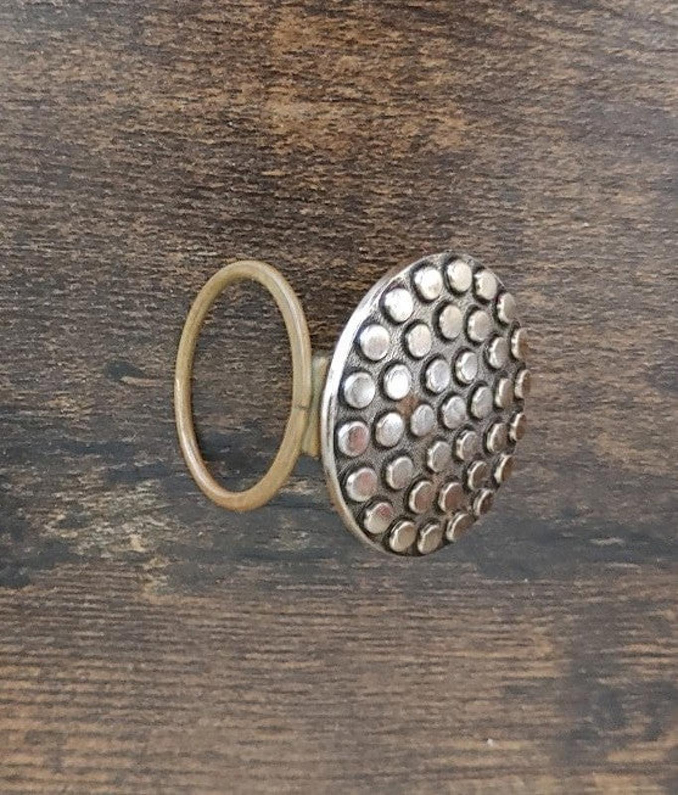 Scarf clip side view with round dotted face and open loop backing