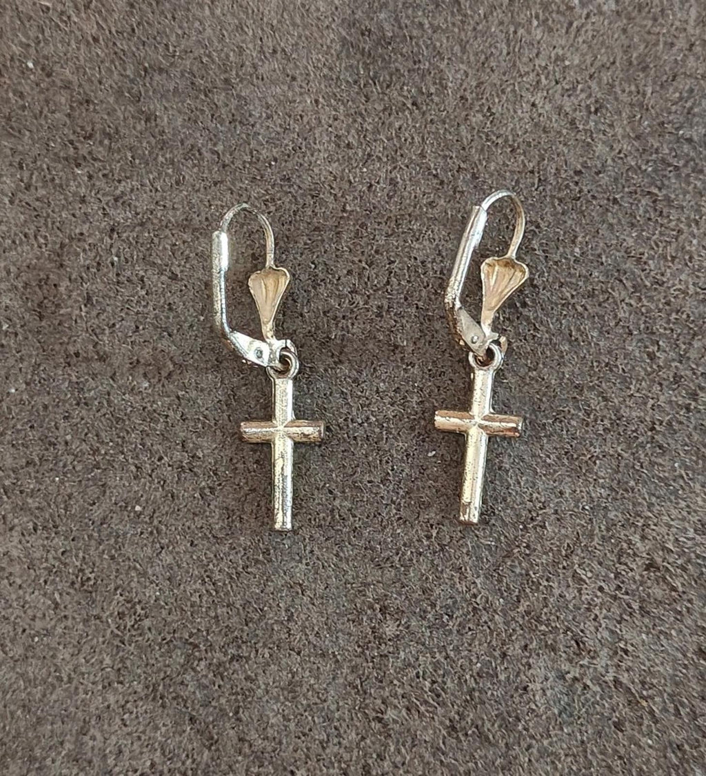Silver-tone cross earrings with heart-shaped top drops and hinged hooks.