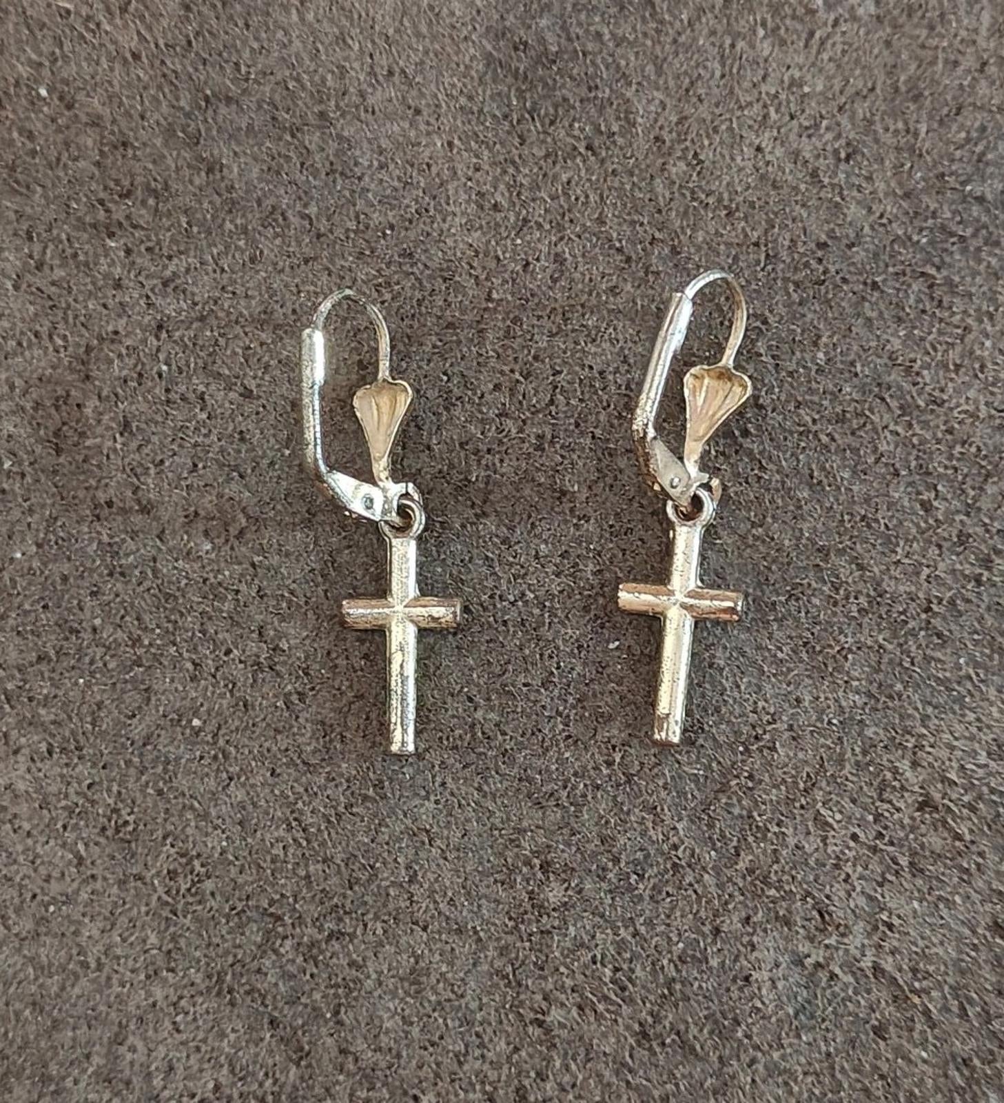 Silver-tone cross earrings with heart-shaped top drops and hinged hooks.