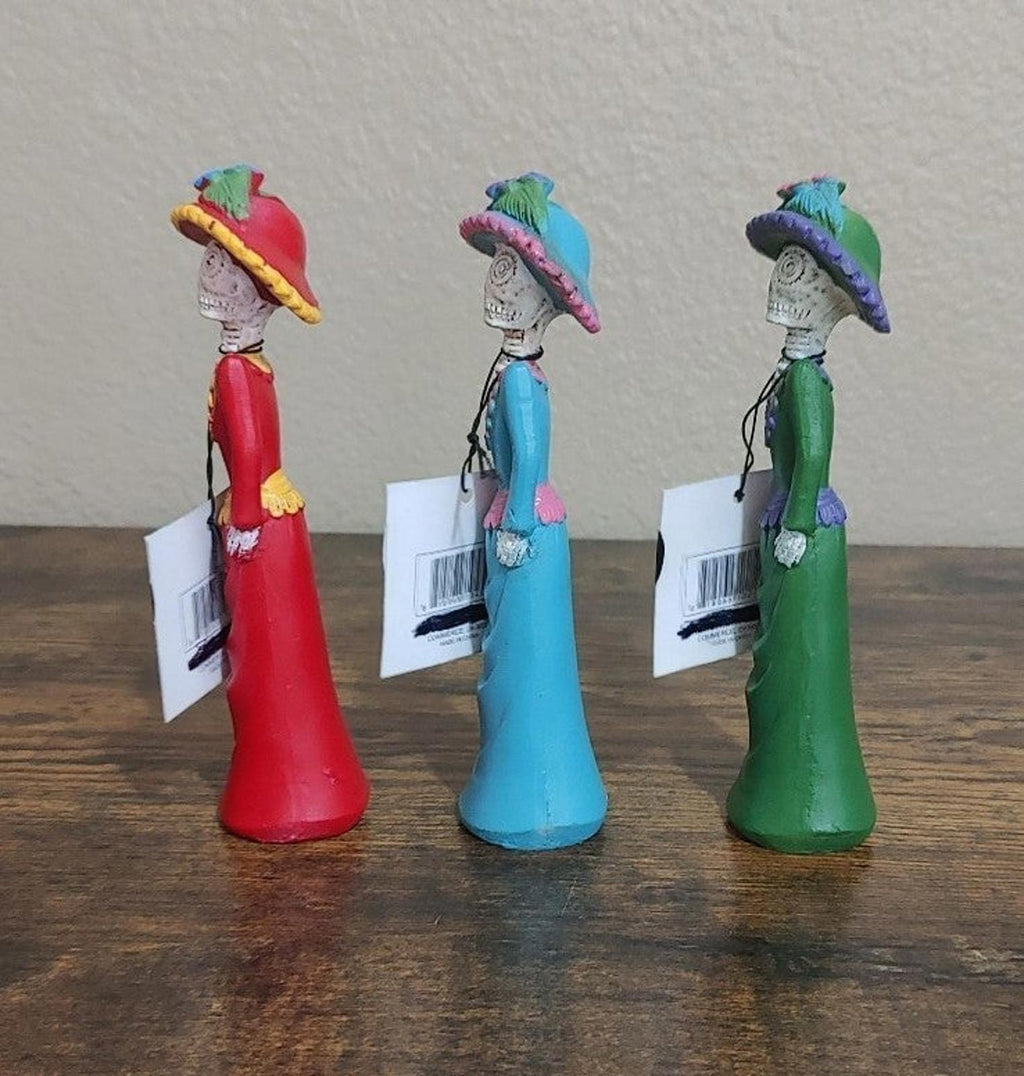 Set of three Day of the Dead lady figurines in red, blue, and green, side views