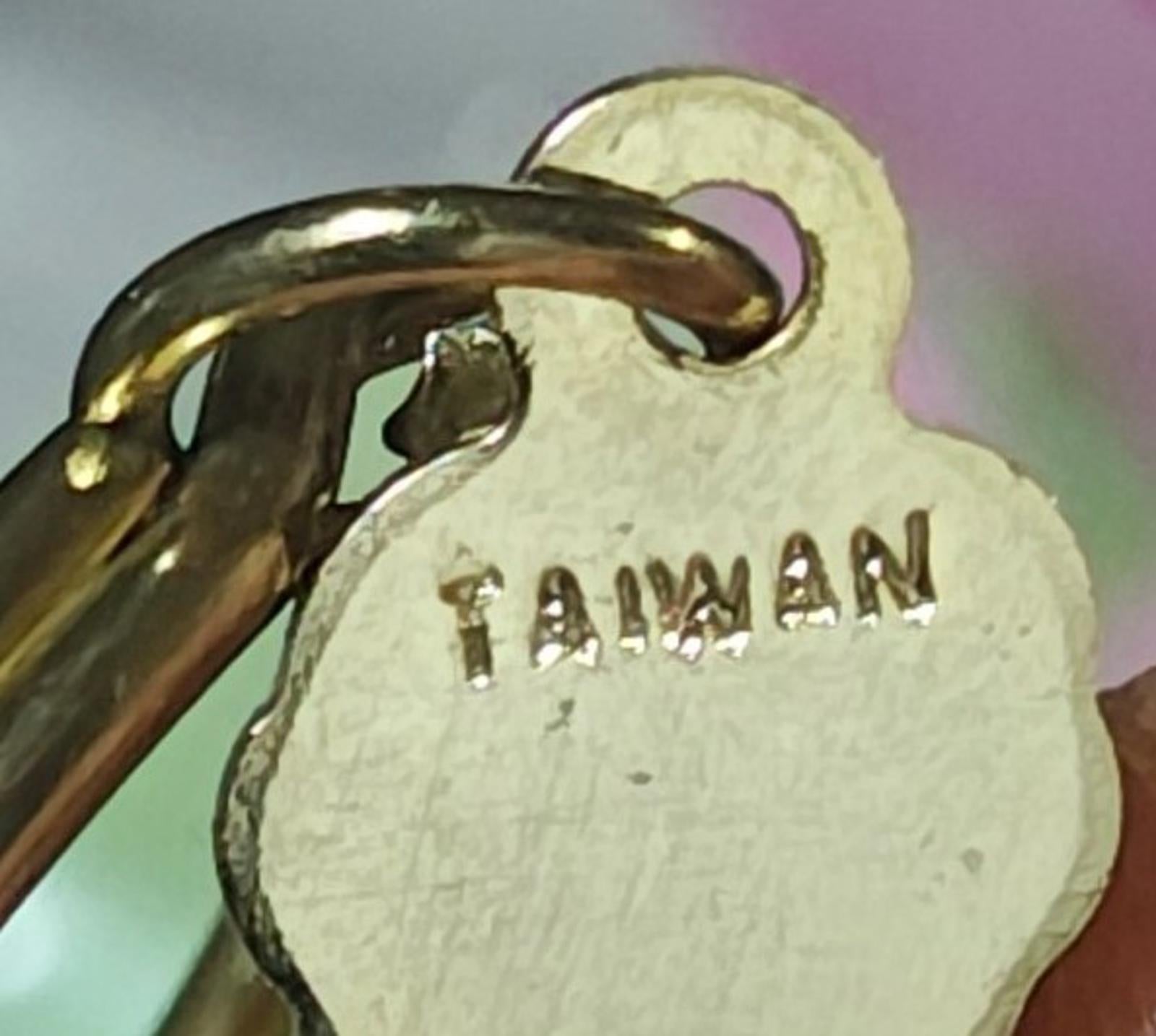 Gold-tone charm close-up with stamped text on a yellowed metal surface