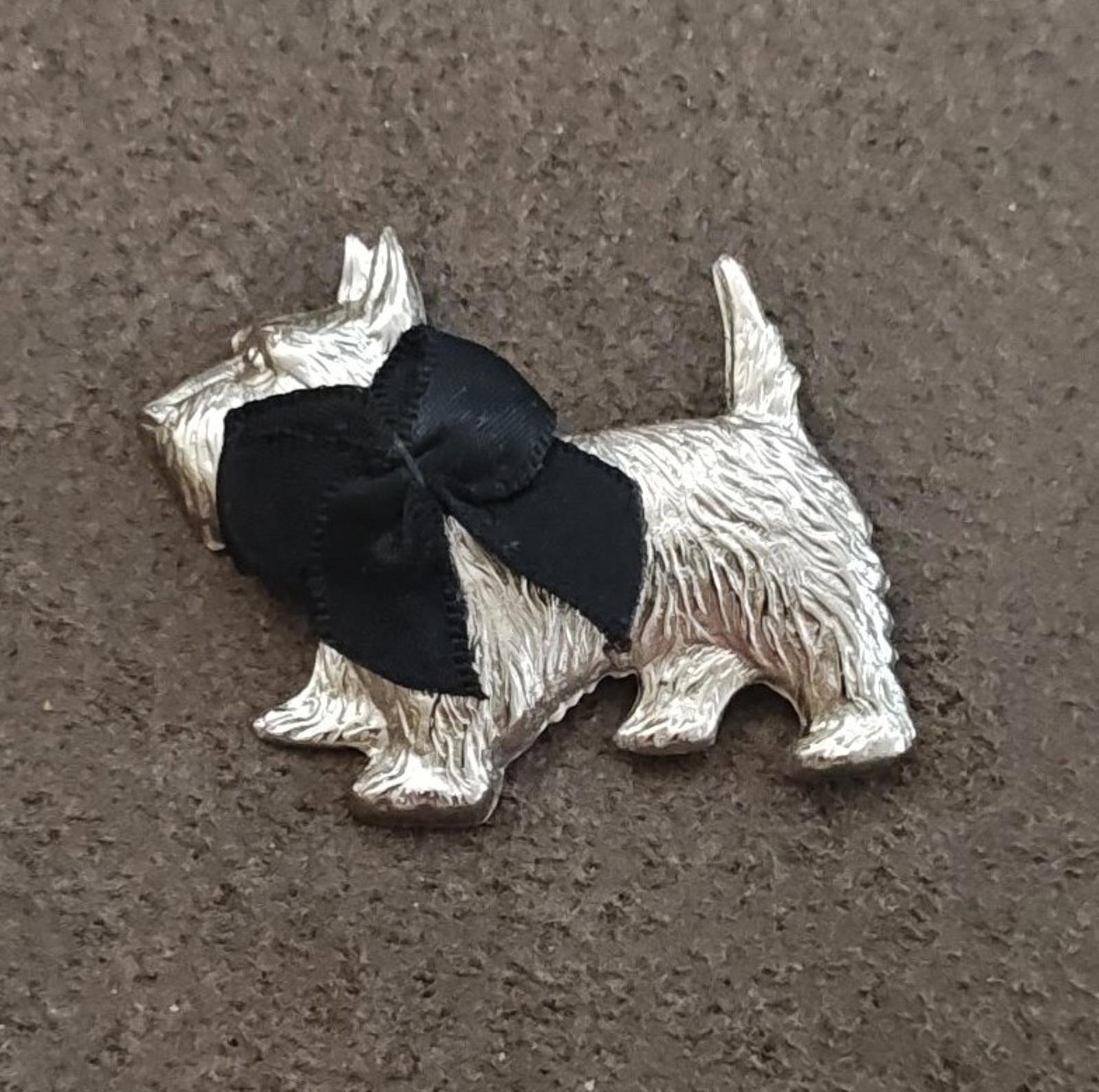 Silver-tone Scottish terrier brooch with black bow, front view