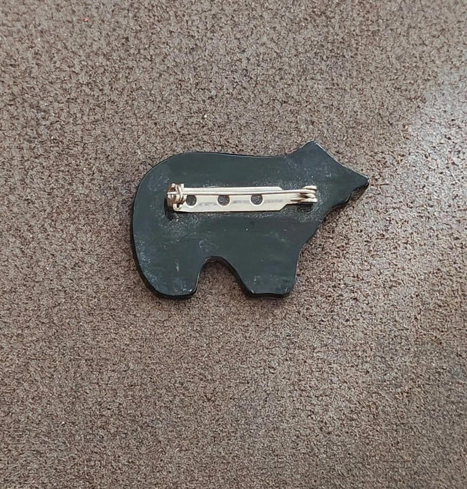 Back of bear brooch with dark backing and silver pin clasp