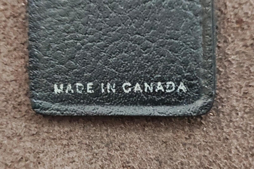 Black leather key fob close-up showing "MADE IN CANADA" on stitched bottom edge