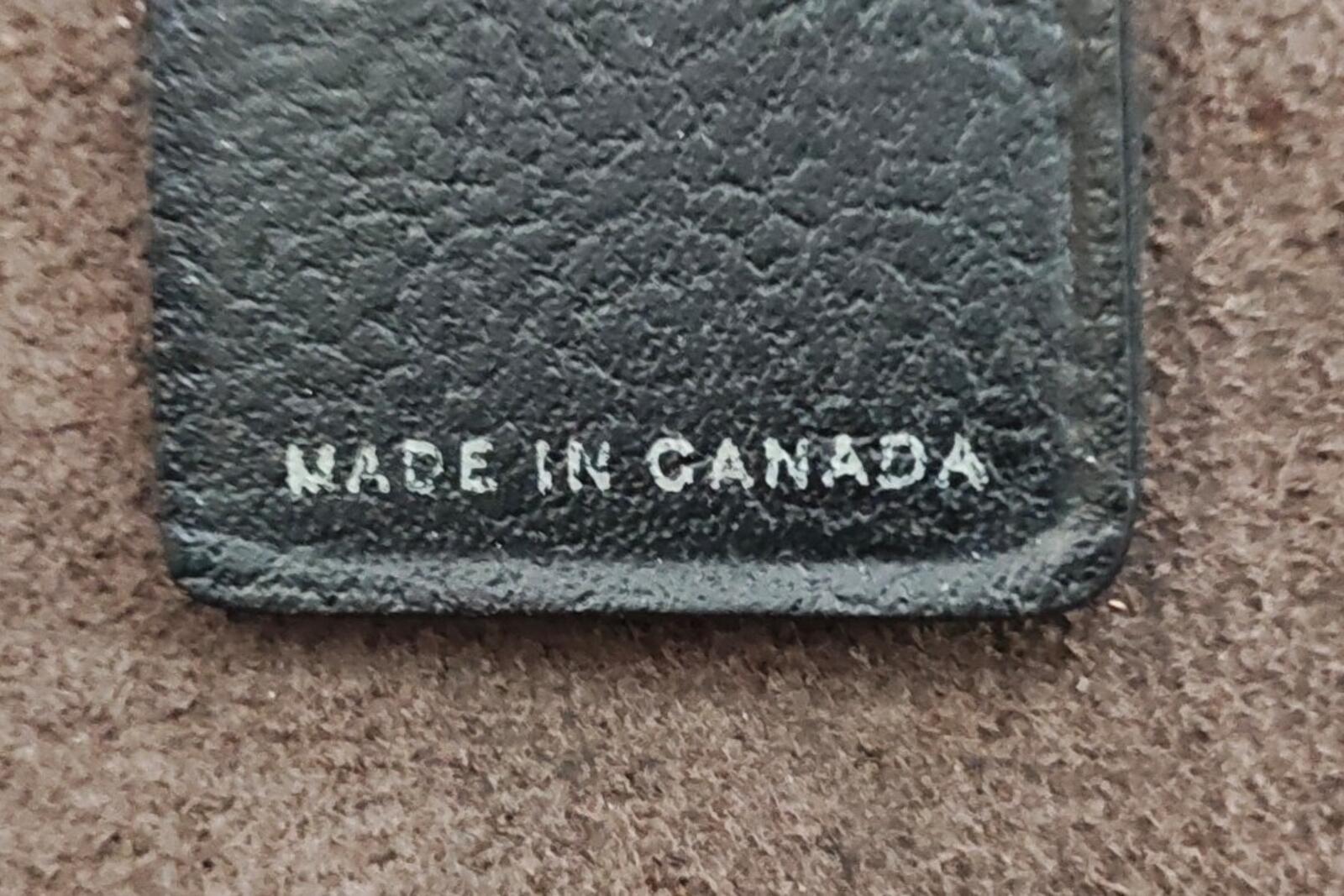 Black leather key fob close-up showing "MADE IN CANADA" on stitched bottom edge