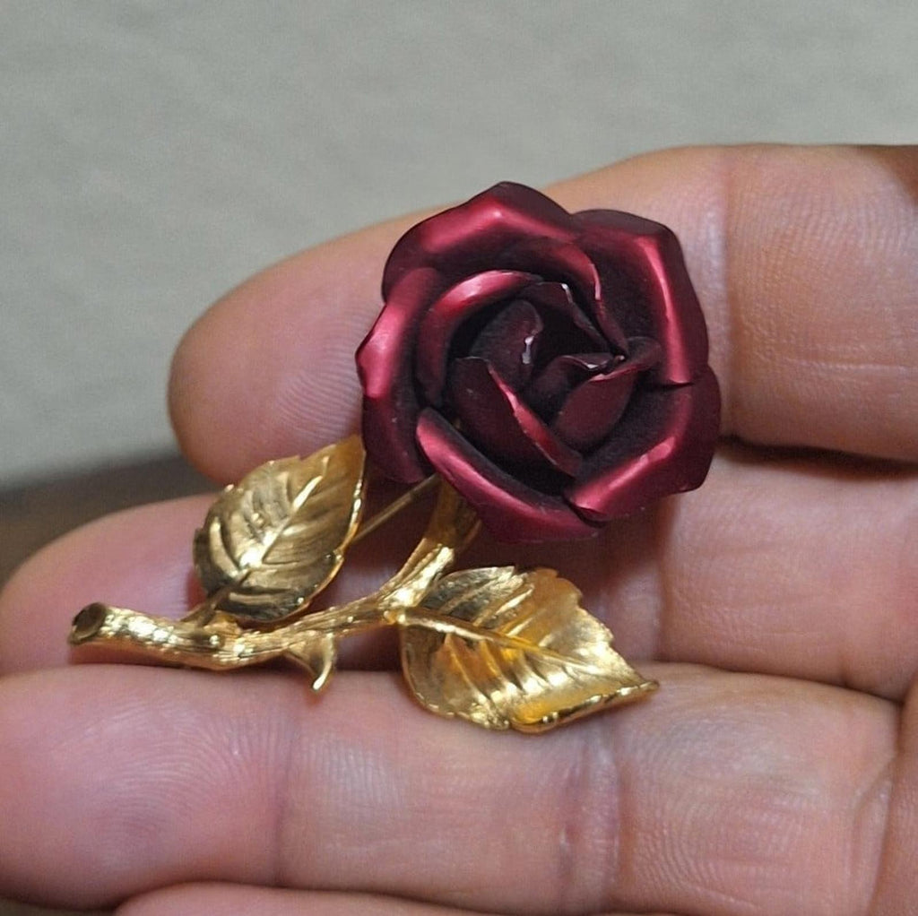 Gold-tone red rose enamel pin brooch, extreme close-up of rose and gold leaves.
