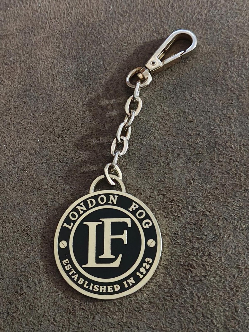 Round black enamel logo keychain with silver-tone chain and spring clip