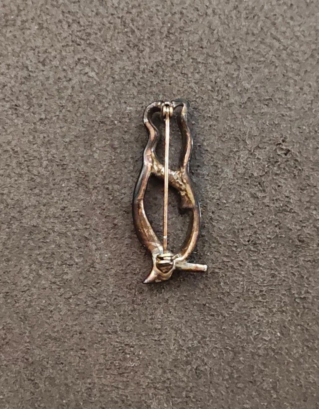 Back view of black enamel penguin brooch with gold-tone clasp and pin