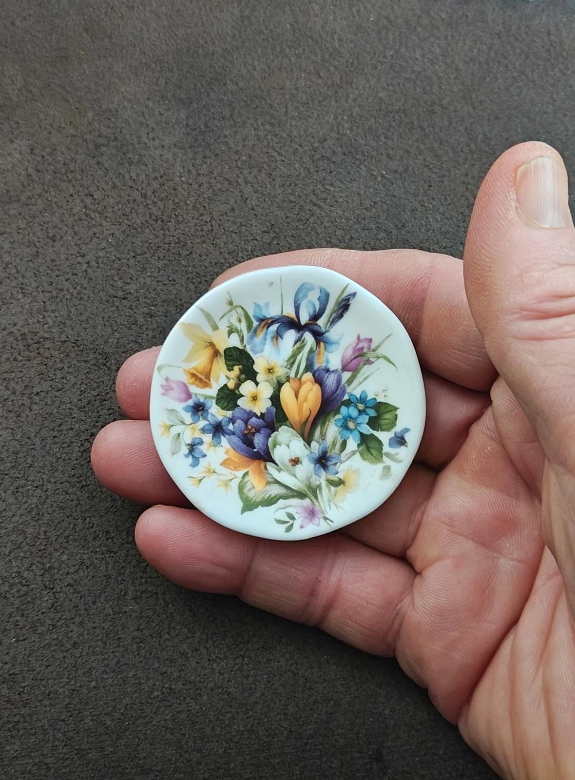 Small floral decorative plate with blue flowers, tulips, and purple accents on a white base