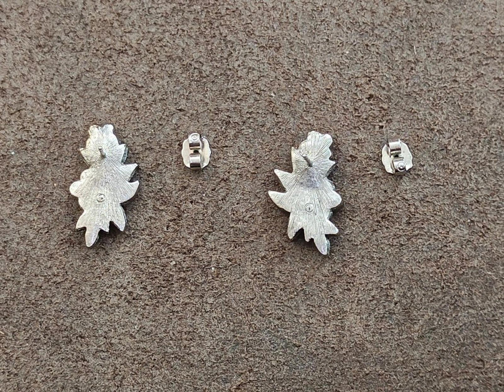 Silver tone starburst earring backs with visible post and clasp on both sides