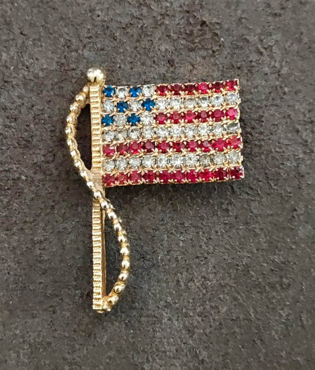Gold-tone American flag rhinestone pin brooch, angled front view with clasp