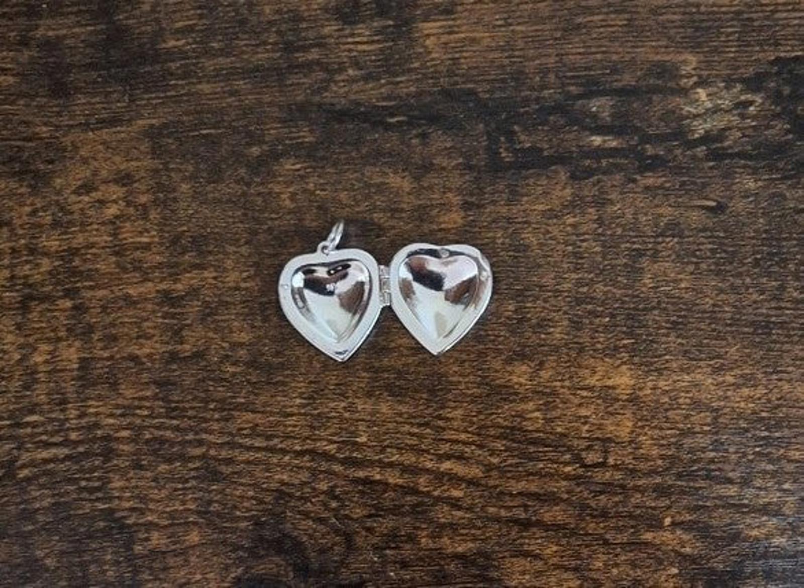 Silver heart locket pendant front and back views with rhinestone detailing