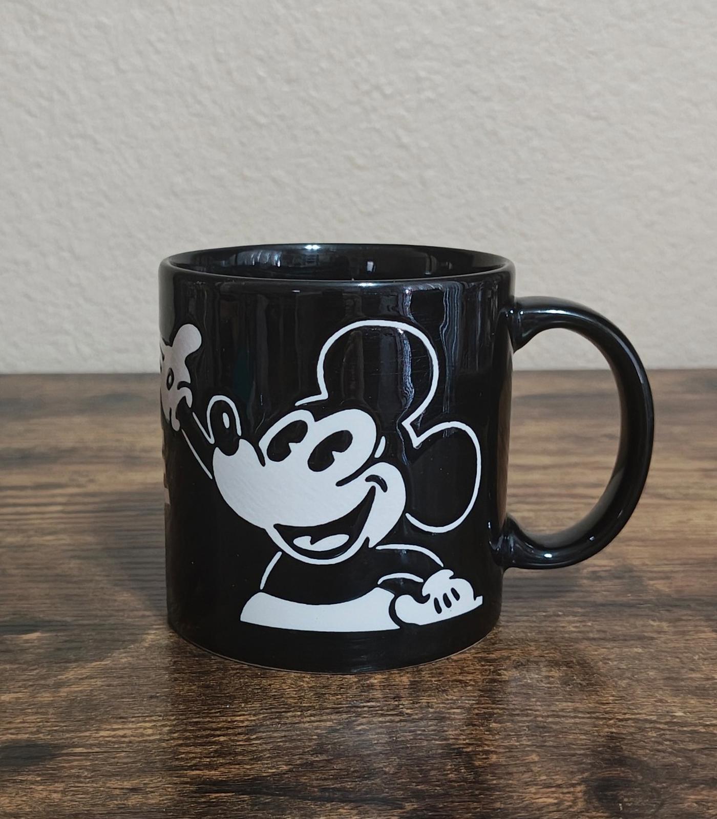 Black mug with white Mickey Mouse character graphic and right-side handle