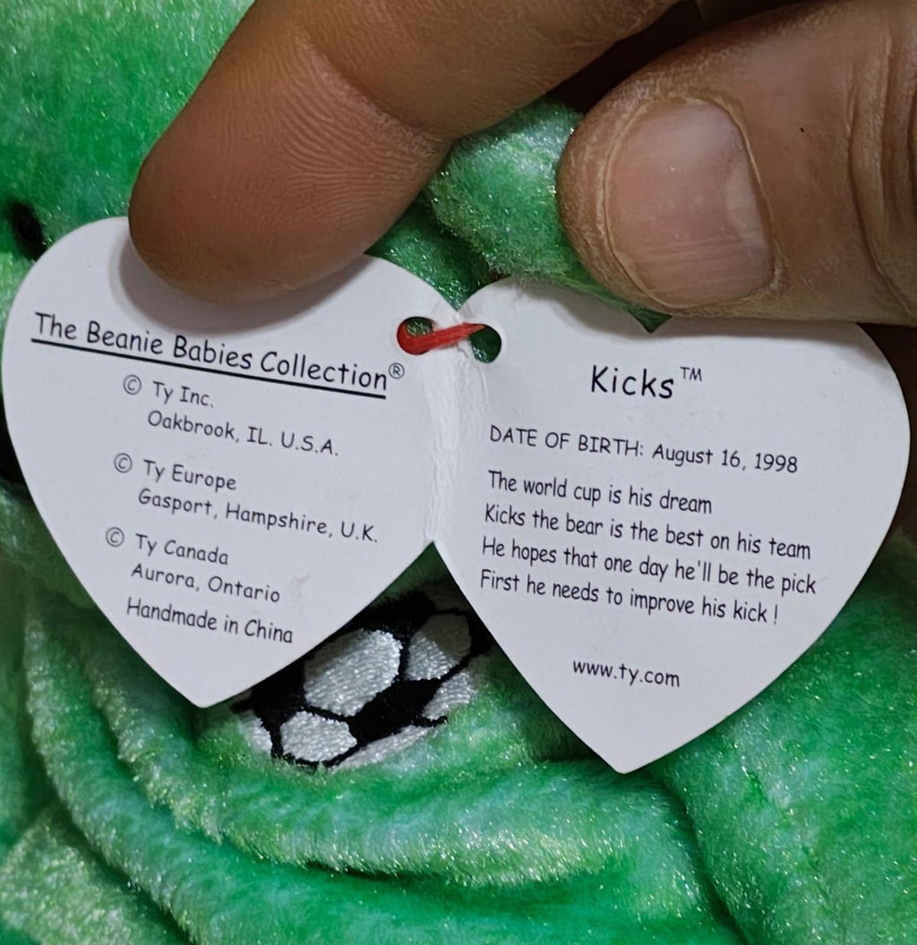 White tush tag with Beanie Babies Collection details on green teddy bear plush.