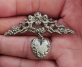 1980s Silver Tone Renaissance Style Cherub Brooch With Dangling Heart Charm
