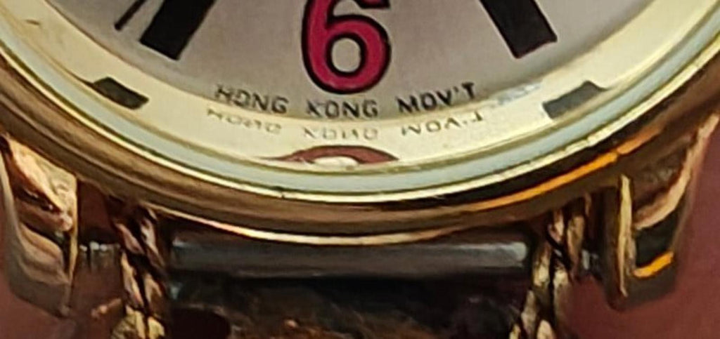 Close-up of watch dial showing number 6 and text “HONG KONG MOVT”