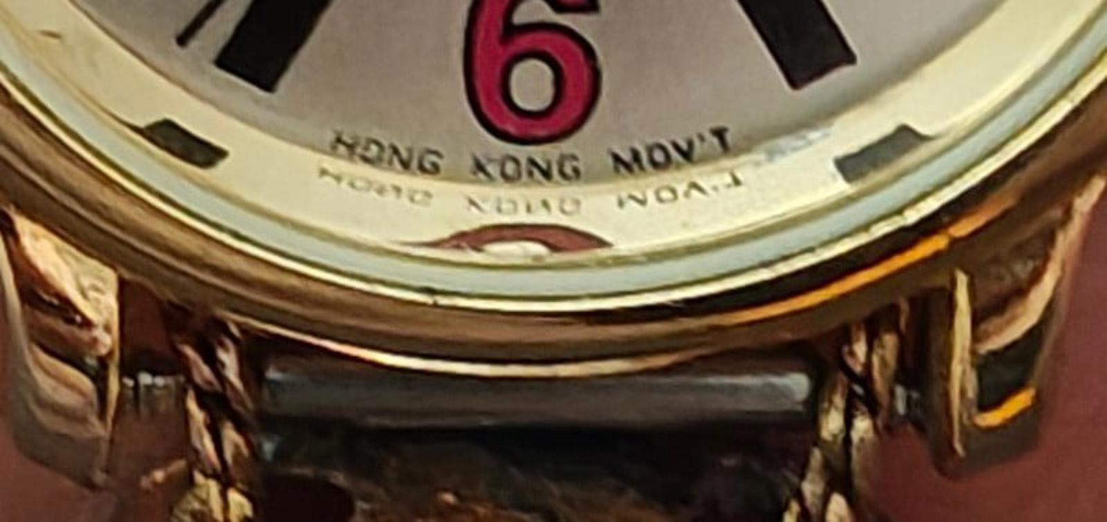 Close-up of watch dial showing number 6 and text “HONG KONG MOVT”