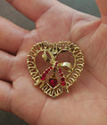 Gold tone heart brooch with red rhinestone accents and dangling center heart