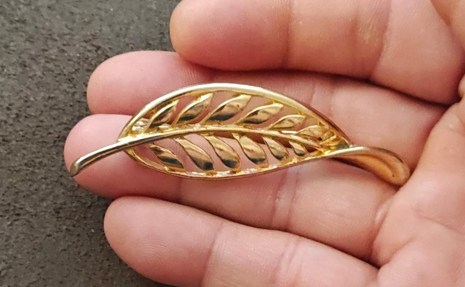 Gold tone leaf brooch with openwork filigree feather motif, arched shape