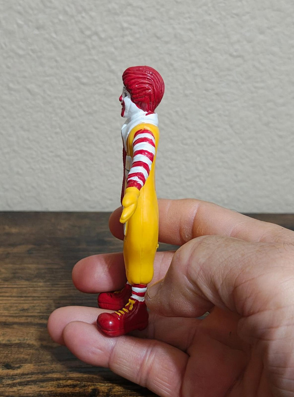 Side view bendable PVC clown figure showing yellow back and red striped sleeves