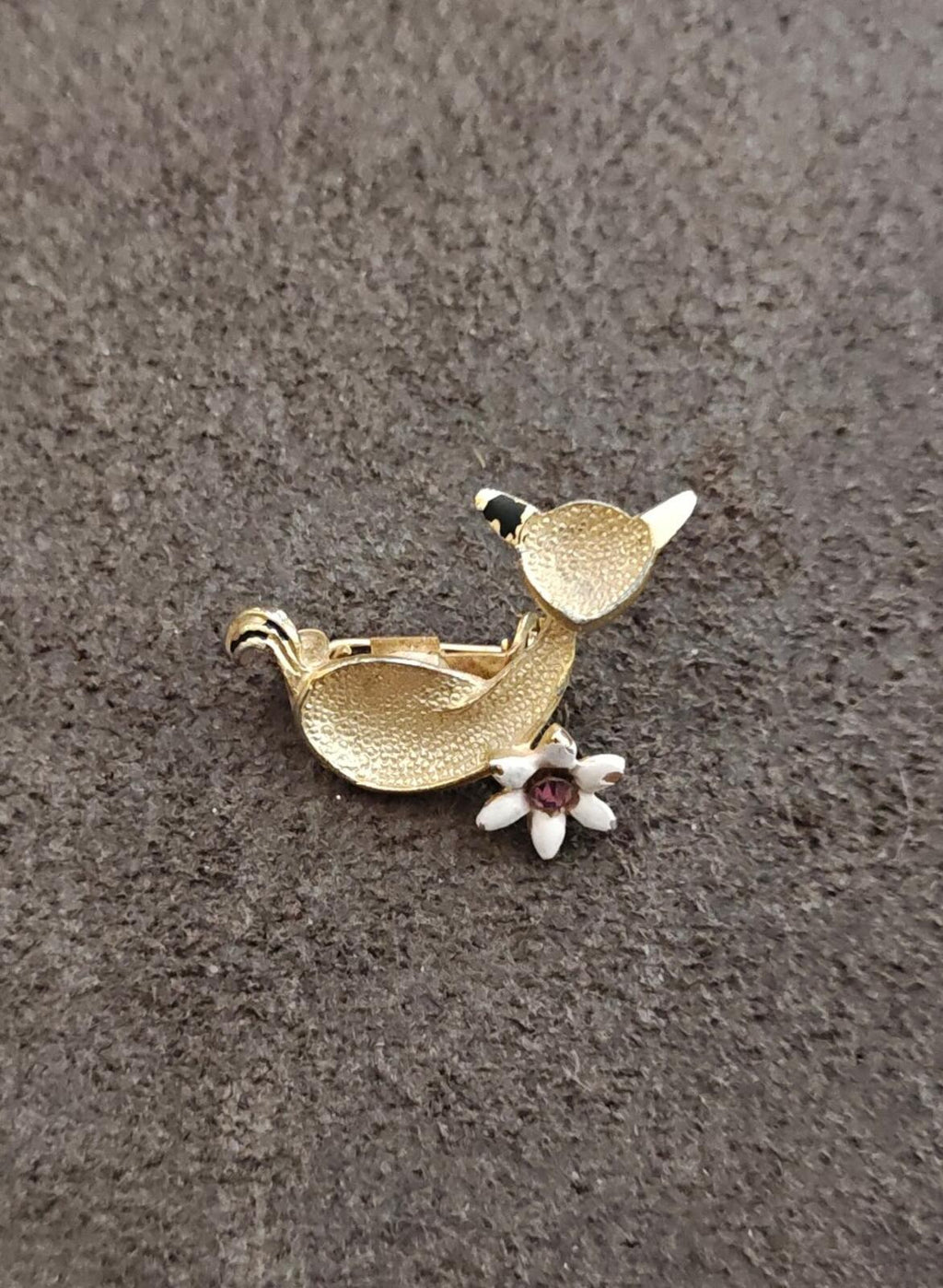 Gold-tone cat brooch with white blossoms and purple rhinestone accent