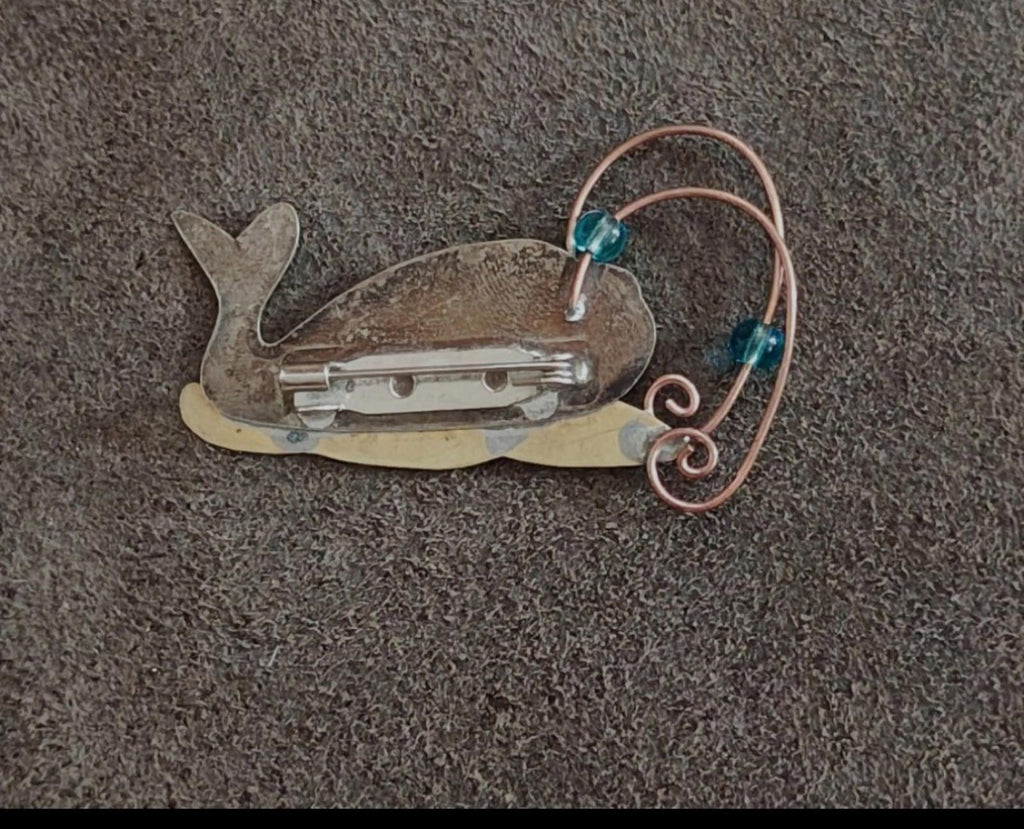 Gold-tone whale brooch pin back with clasp bar, blue stones, and copper wire swirl
