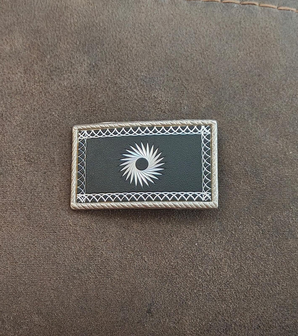 Western belt buckle centered shot: silver starburst on black inset with rope frame