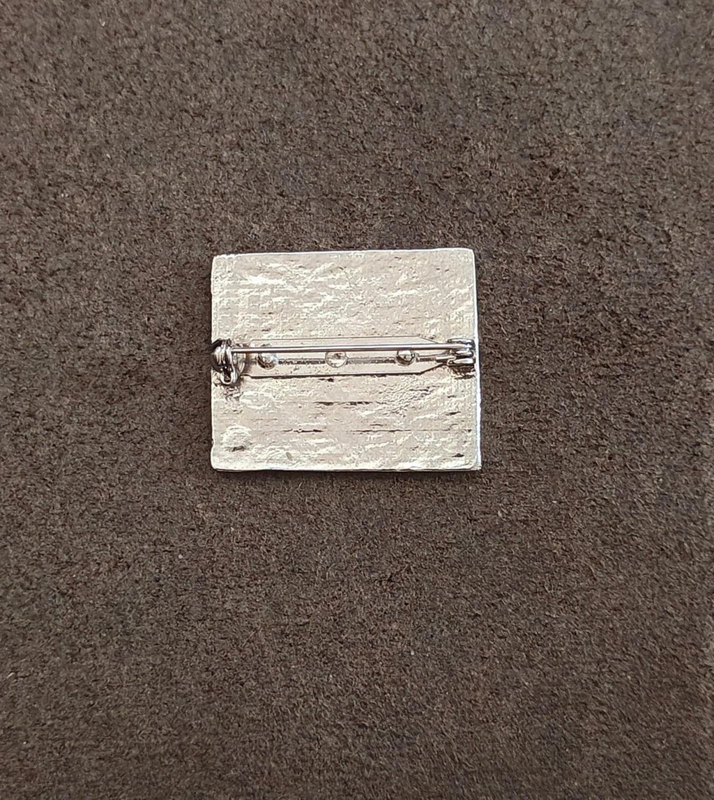 Silver-toned brooch pin backing with clasp and safety catch, flat rectangular plate
