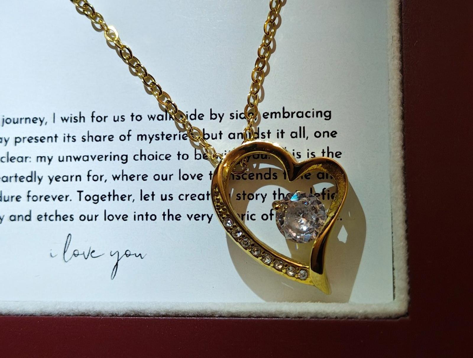 Gold tone heart pendant necklace with crystal-like center and heart bezel detail