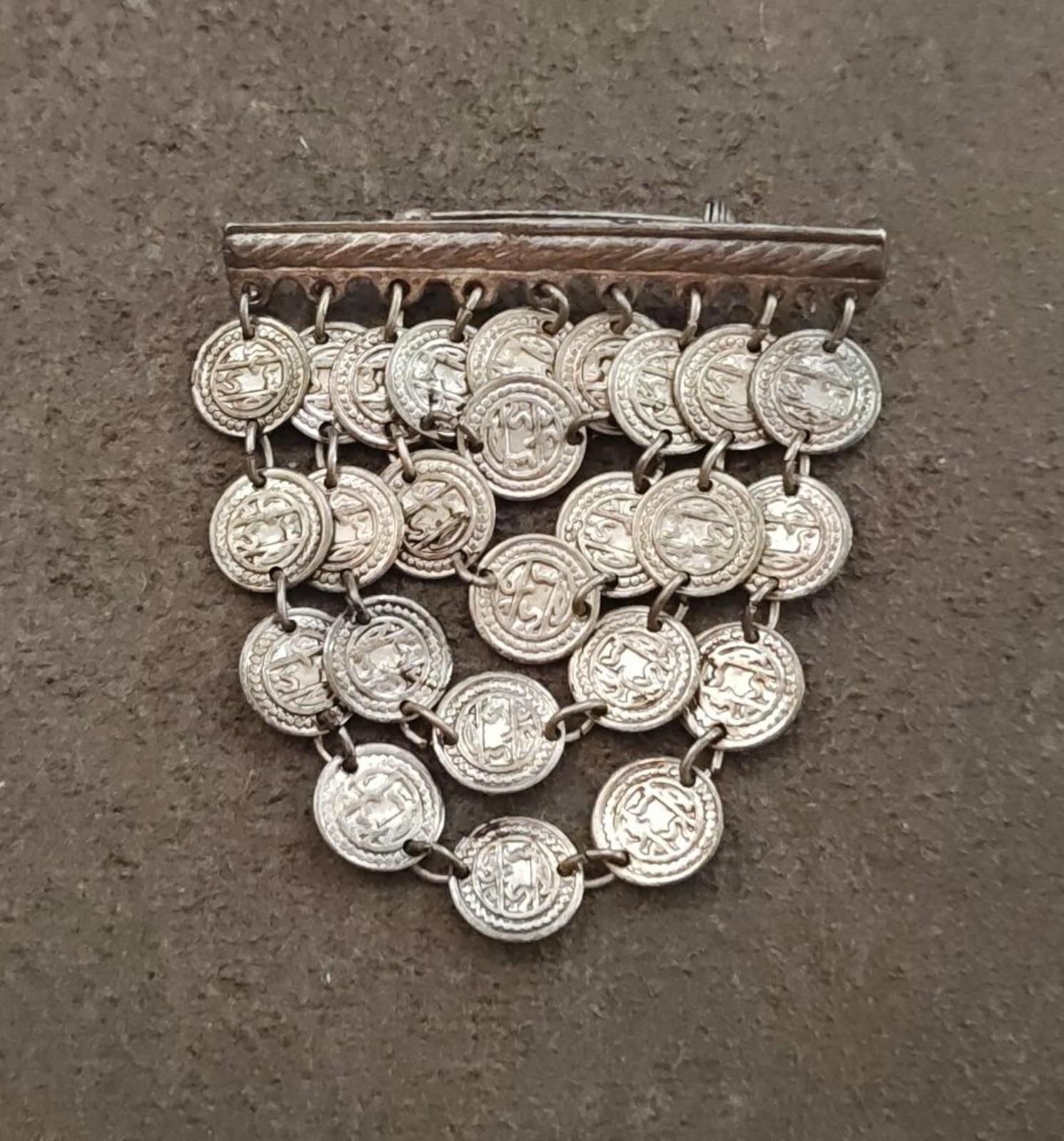 Silver-tone coin dangle brooch with layered round coin charms and rectangular top bar