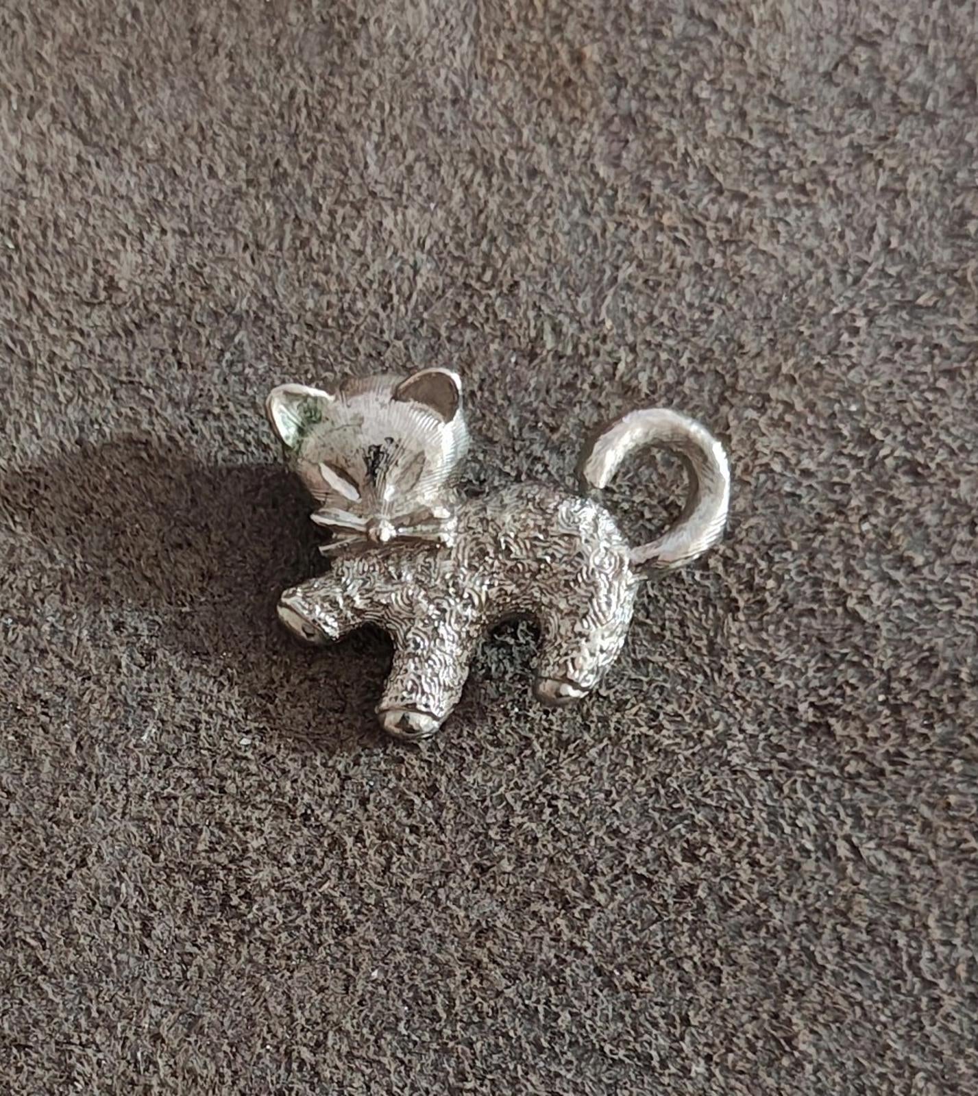 Silver-tone textured cat brooch pin with bow and raised ears.