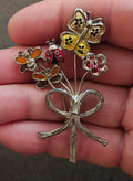 Silver-tone bouquet brooch with yellow, red, pink flowers and ladybug charms