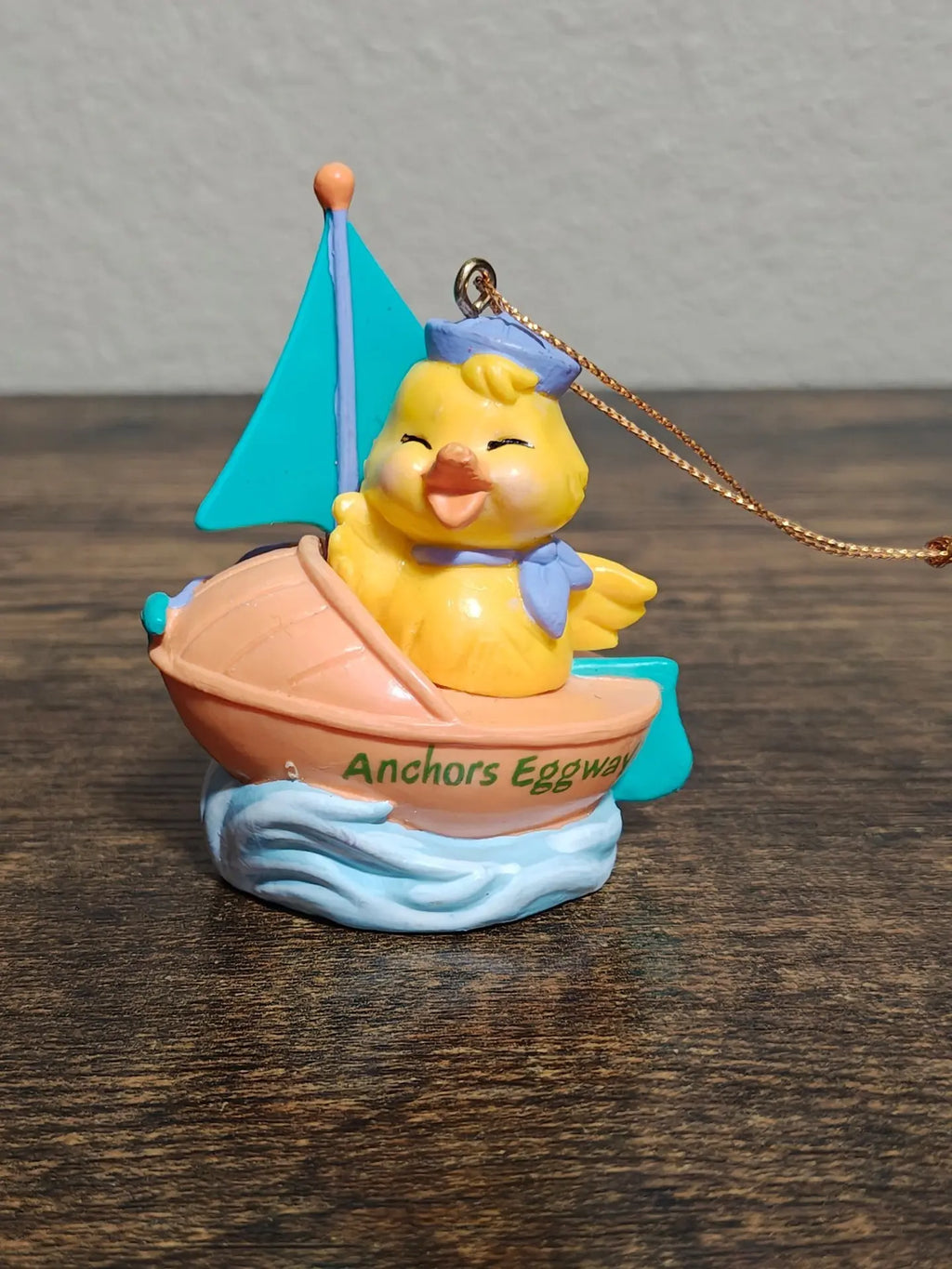 Easter sailboat ornament with yellow chick face, teal sail, peach boat, and gold chain