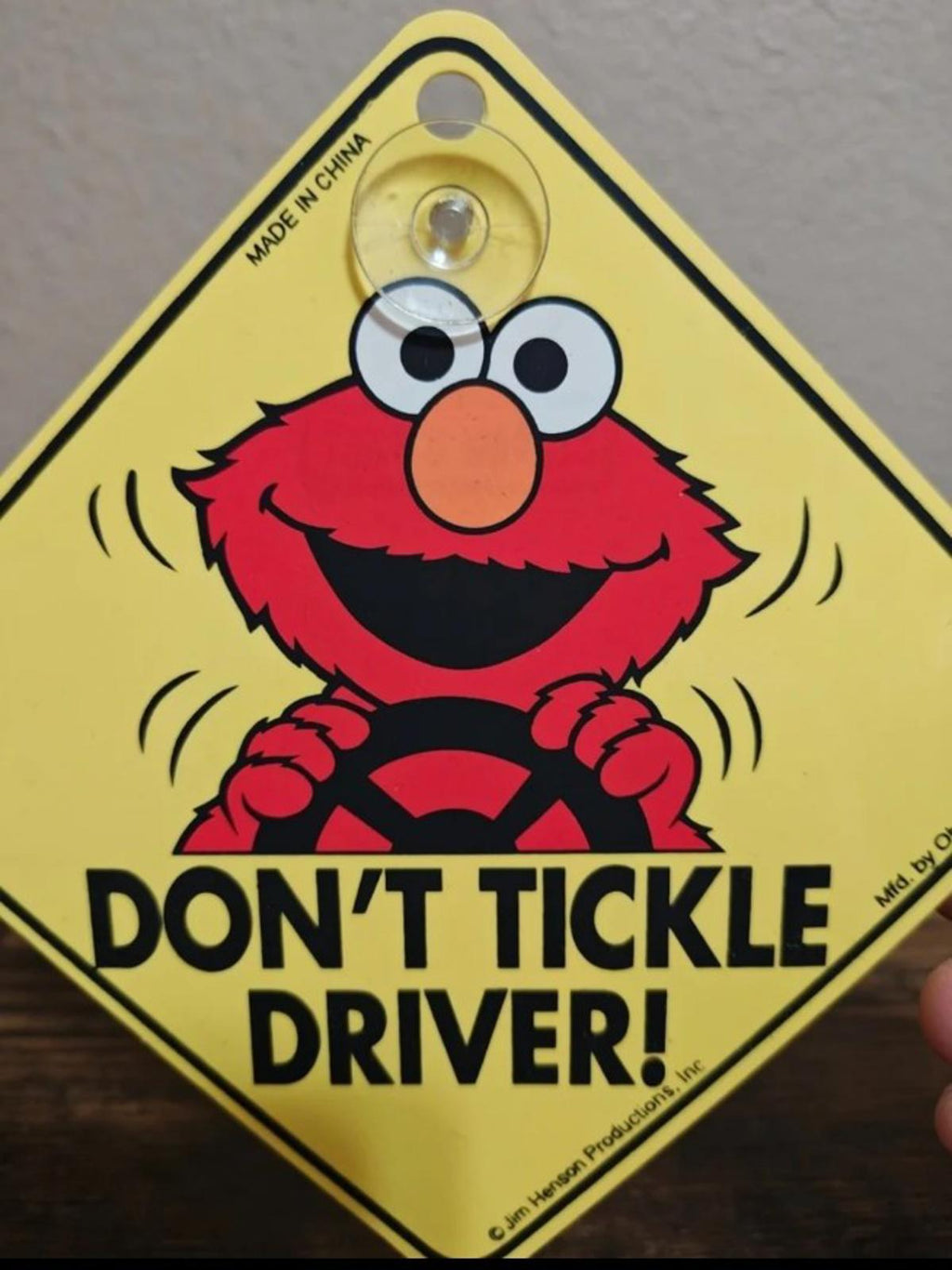 Close view of yellow Elmo car window sign with “DON’T TICKLE DRIVER!” warning