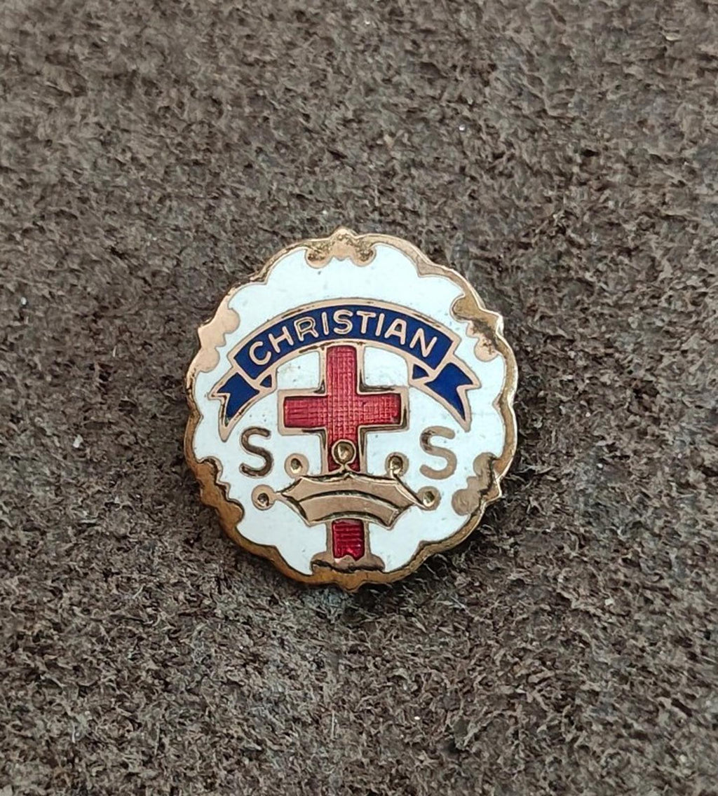Round gold tone Christian pin with red cross, blue accents, and “CHRISTIAN S.O.S.”