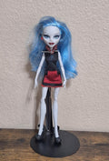 Monster doll with long light-blue hair, black top, red skirt, striped necktie, boots