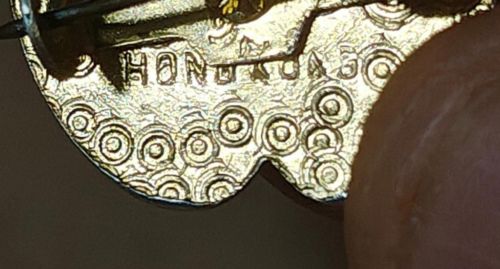 Gold-tone engraved back of footprint brooch pin with decorative scrollwork