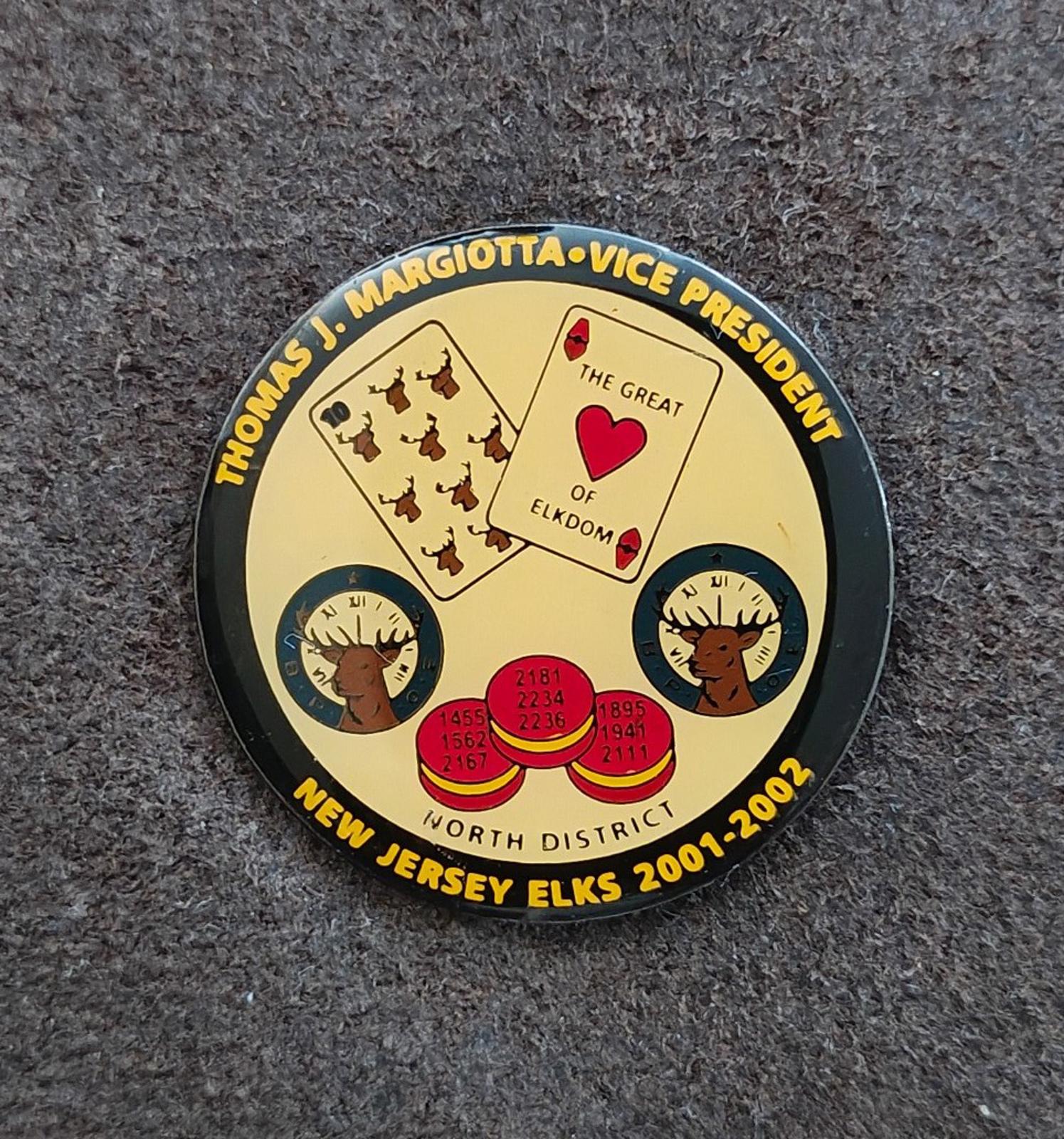 Gold tone lapel pin with yellow emblem, black border, and colored insignia details.