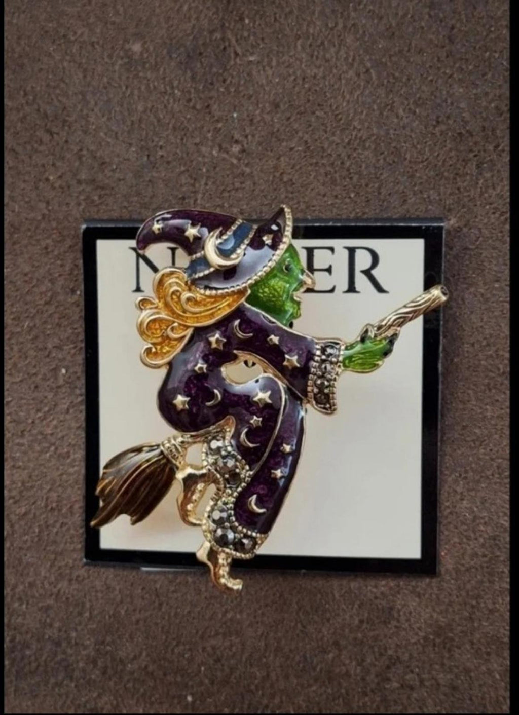 Gold-tone witch enamel pin brooch featuring dark purple star cloak and green broom