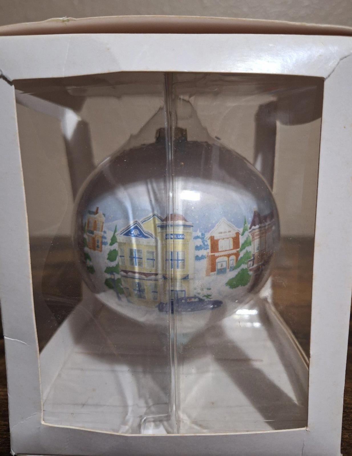 Hallmark Keepsake teardrop ornament with Main Street buildings and a tall tower detail