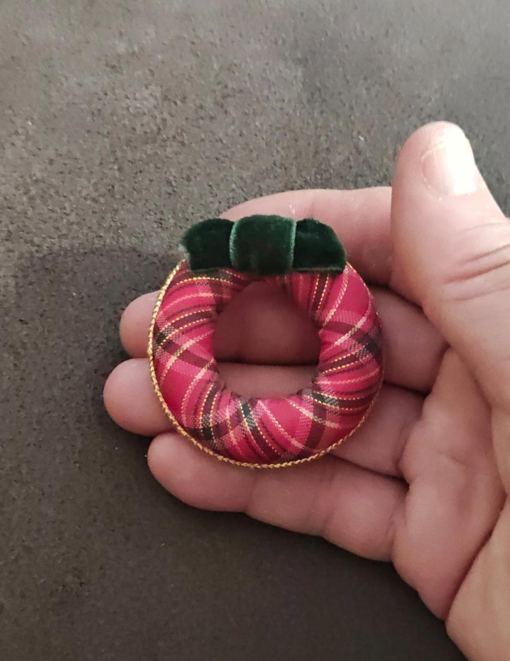 Plaid wreath brooch with pink/red check pattern, green bow, and gold edging