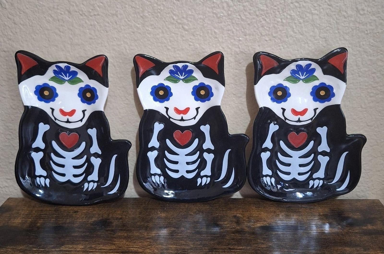 Three black 3D cat sugar skull trinket plates with blue floral crown and red heart