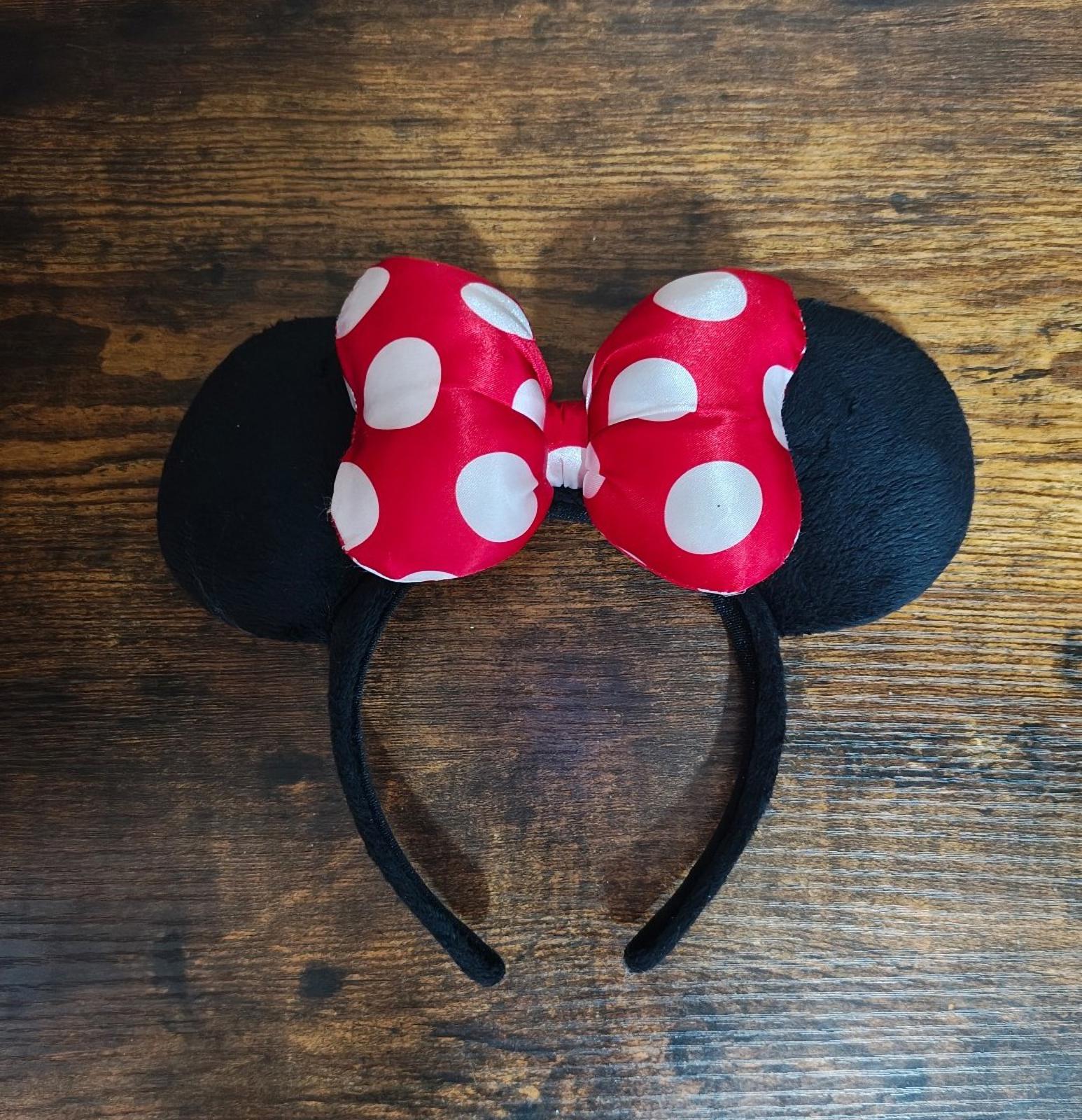 Red and white polka-dot bow ear headband with black fabric ears, centered