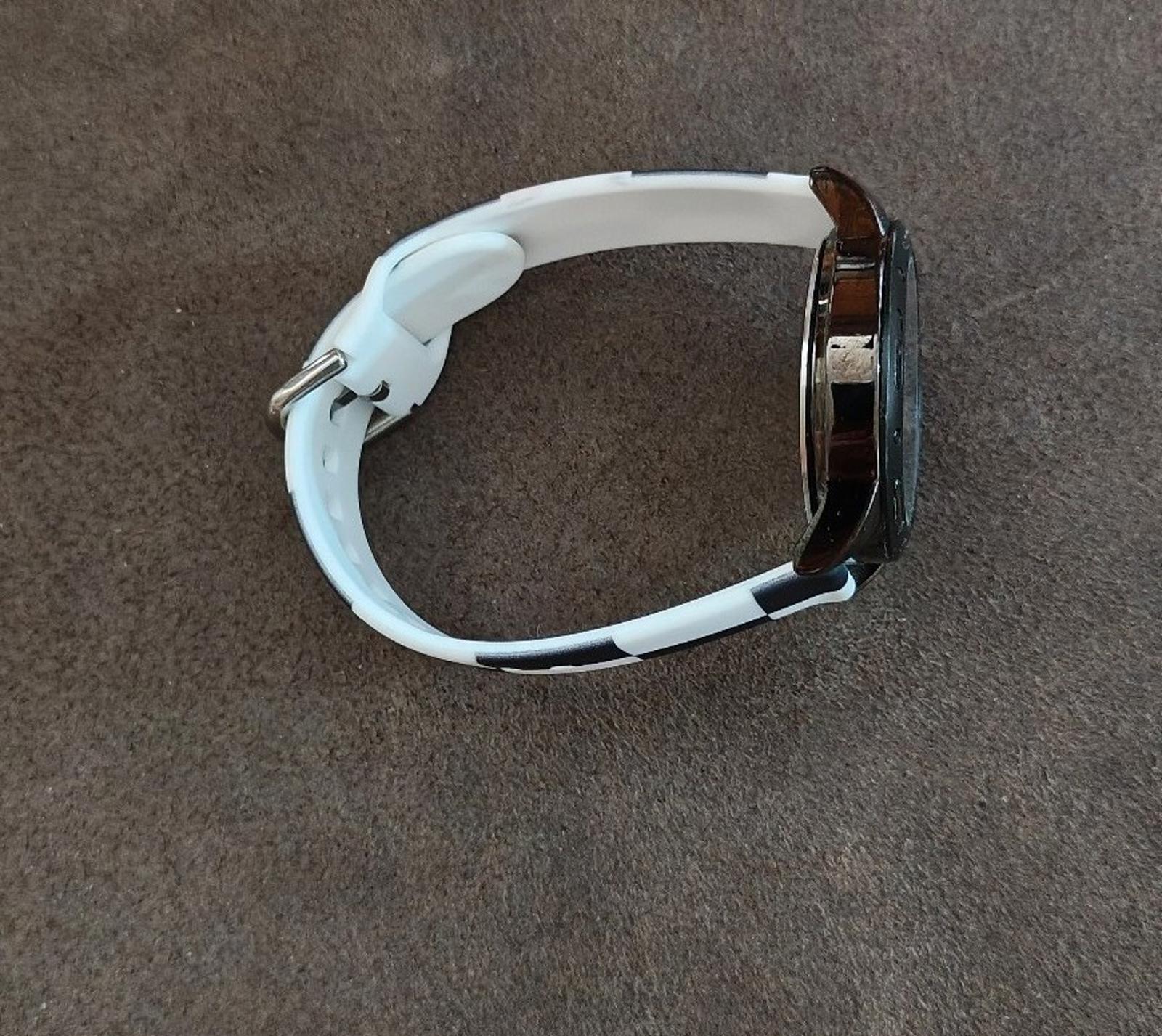 Side view of watch with white silicone band and metal clasp hardware