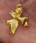 Gold-tone angel pin/brooch with raised wings and a hanging bell charm