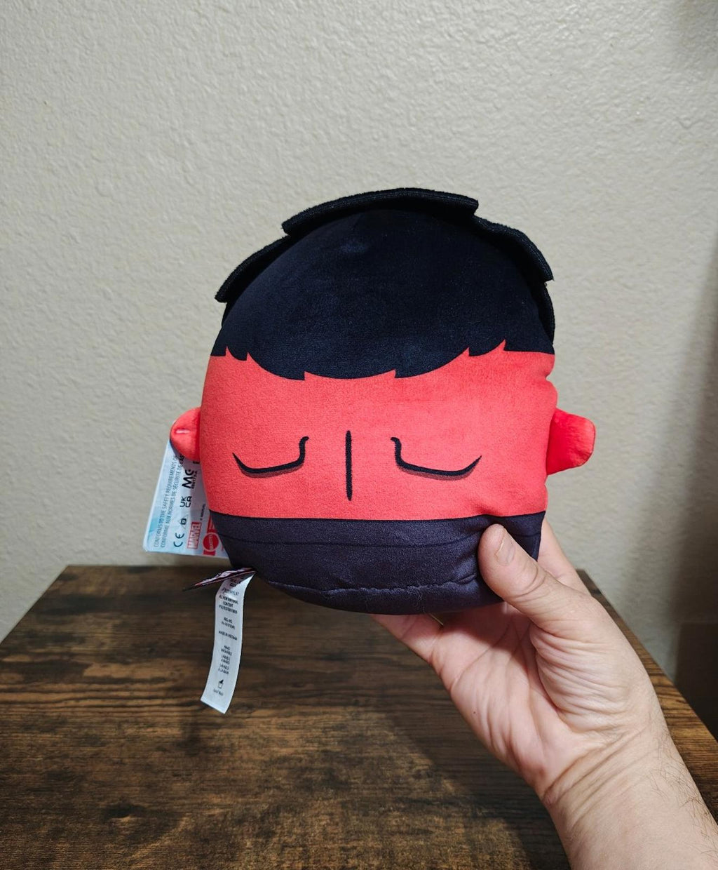 Back view red and navy soft plush toy with small hang tag on side