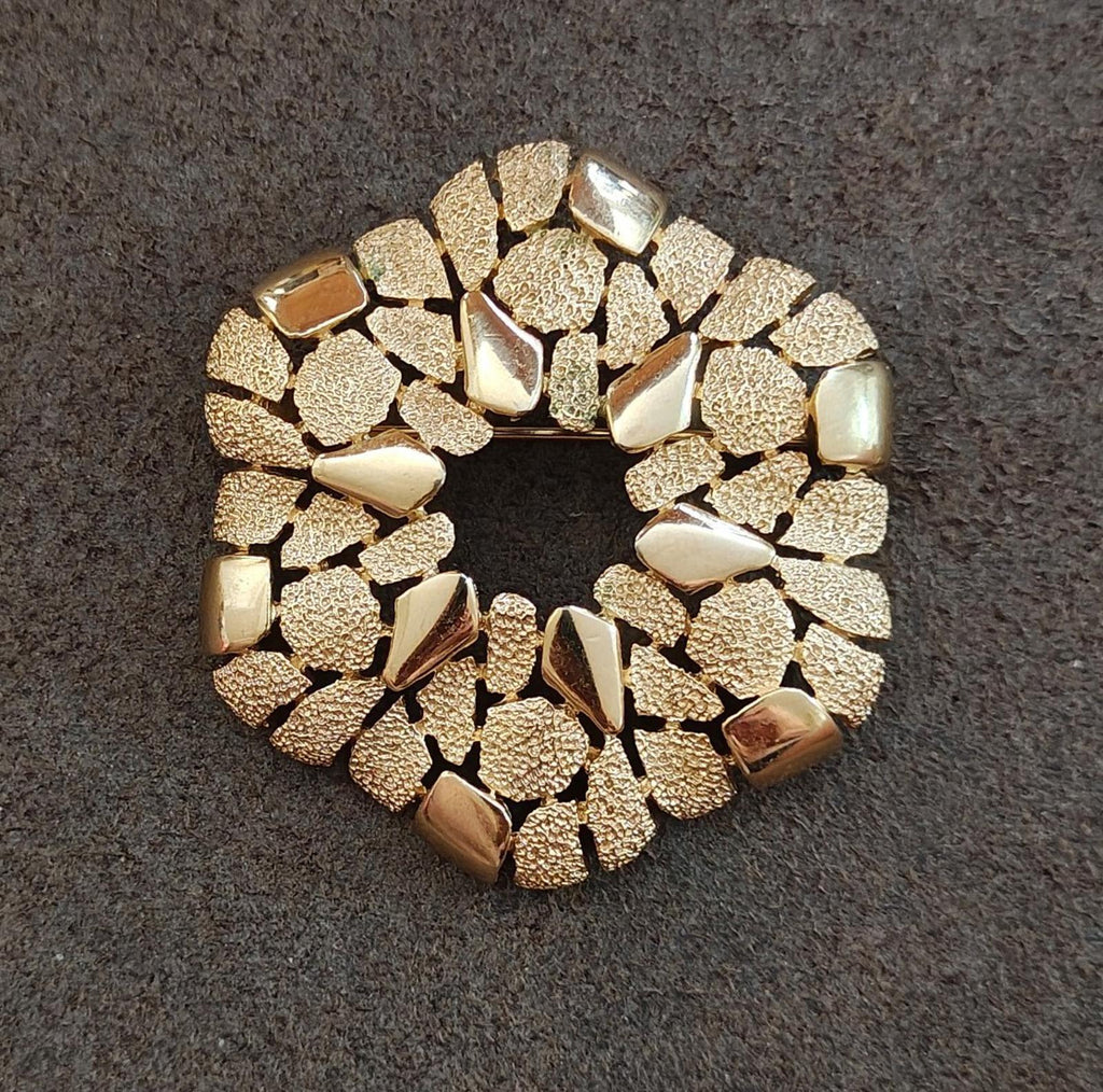 Gold-tone cobblestone wreath brooch viewed from the side, textured rim