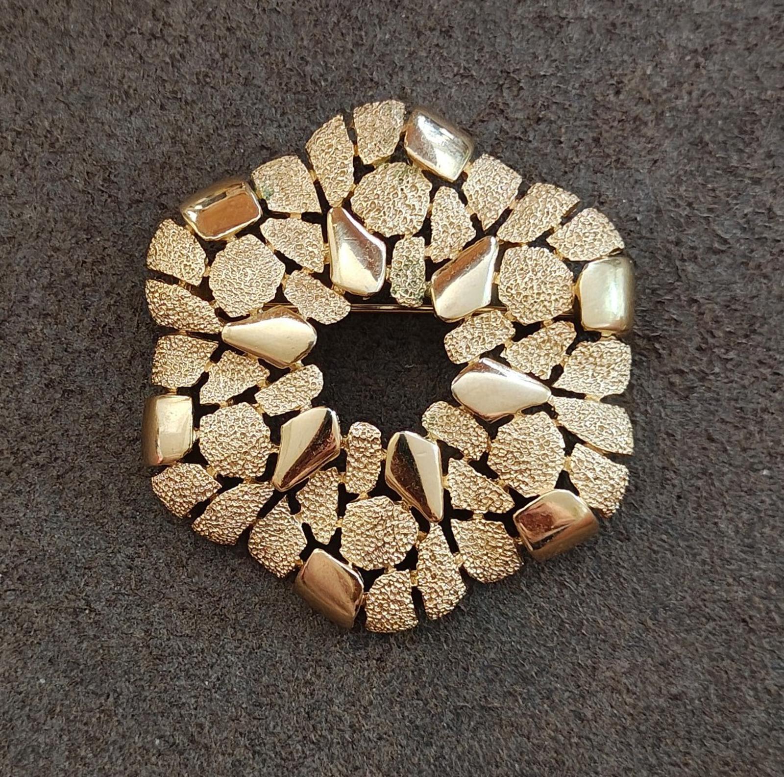 Gold-tone cobblestone wreath brooch viewed from the side, textured rim