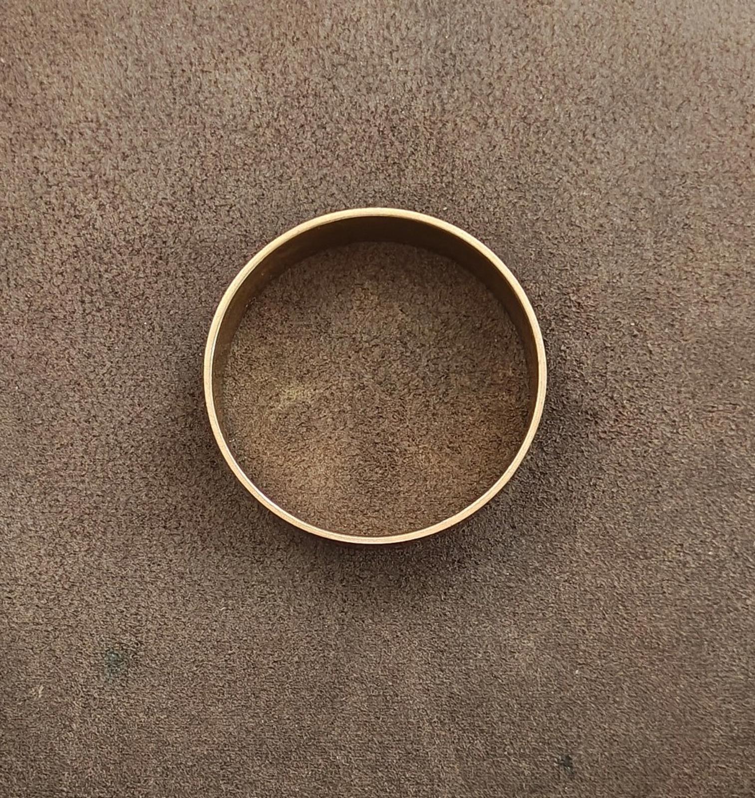 Gold-tone open cuff bangle bracelet, plain side view.